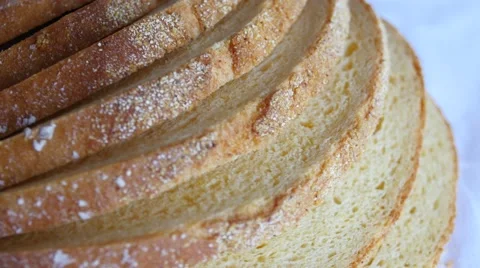 Sliced loaf of bread slowly rotating on white Video stock 47790531