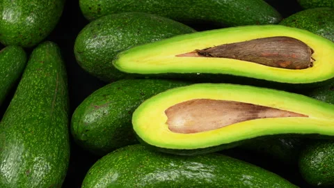 Sliced Long Avocado Halves with Pit on Fresh Avocado Pile 스톡 동영상 336492212