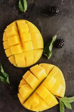Sliced mango accompanied by mint leaves Stock Photos