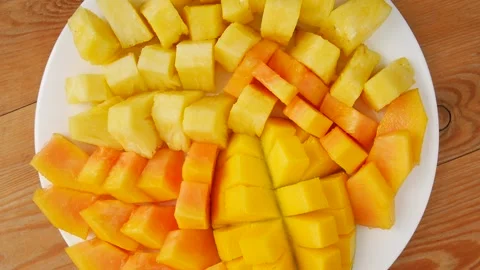 Sliced mango, papaya, pineapple on a pla... | Stock Video | Pond5