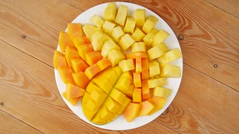 Sliced mango, pineapple, papaya on a plate. Stock Footage 240079196