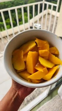 Sliced ??mango in a white pot overlooking nature. Stock Photos