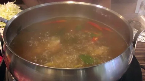 Sliced meat is being dipped in the hot boiling soup japanese shabu-shabu Stock Footage 77374215