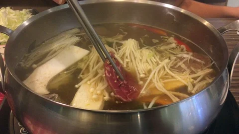 Sliced meat is being dipped in the hot boiling soup japanese shabu-shabu Stock Footage 77410352