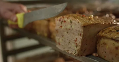 Sliced meat loaf with pepper pieces on a baking tray, Food Factory Vídeo Stock 340013140