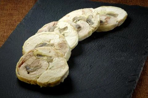 Sliced Meat Roll Served on a Black Ceramic Board With Spinach and Sunflower.. Stock Photos