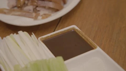 Sliced Meat, Sauce, and Vegetables Served on Table in Beijing Restaurant Stock Footage 345766320