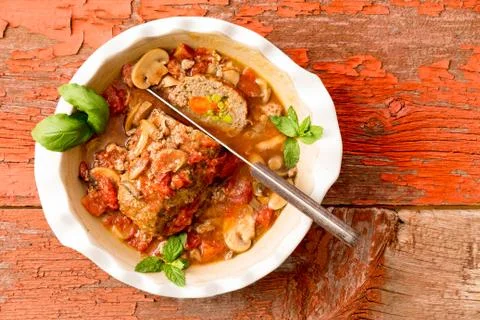 Sliced meatloaf in a casserole on a rustic table Stock Photos