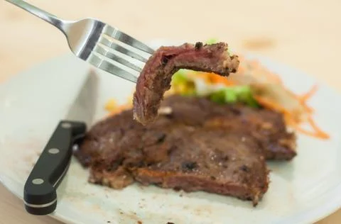 Sliced medium rare grilled Beef steak Ribeye with vegetable salad white plate Stock Photos