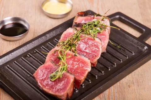 Sliced medium rare grilled Beef steak Ribeye with basil and cherry tomatoes Stock Photos