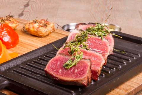 Sliced medium rare grilled Beef steak Ribeye with basil and cherry tomatoes Foto stock