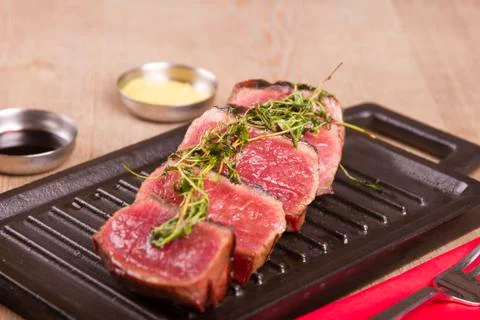 Sliced medium rare grilled Beef steak Ribeye with basil and cherry tomatoes Stock Photos