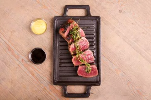 Sliced medium rare grilled Beef steak Ribeye with basil and cherry tomatoes Stock Photos