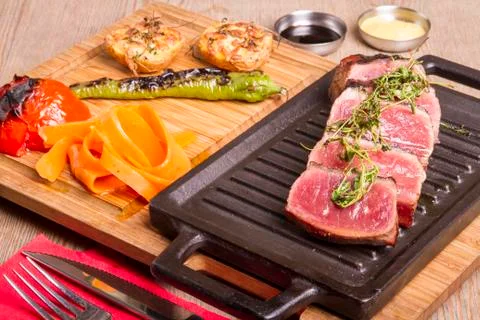 Sliced medium rare grilled Beef steak Ribeye with basil and cherry tomatoes Stock Photos