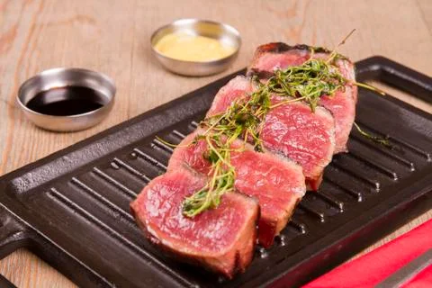 Sliced medium rare grilled Beef steak Ribeye with basil and cherry tomatoes Stock Photos