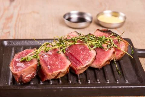 Sliced medium rare grilled Beef steak Ribeye with basil and cherry tomatoes Stock Photos