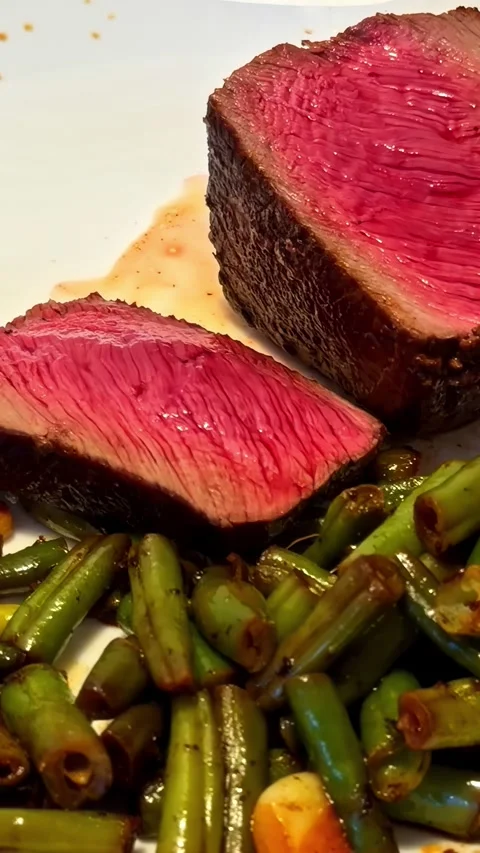 Sliced Medium Rare Steak With Green Beans on Dinner Plate Stock Footage 336240254