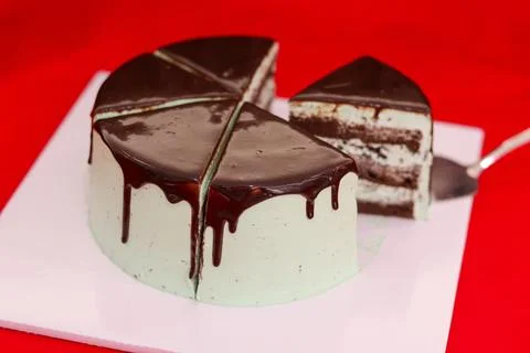 Sliced Mint Chocolate Layer Cake with Ganache Drip on Red Photos