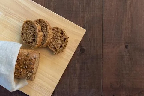 Sliced multi seeded baguette on a bread board 스톡 사진