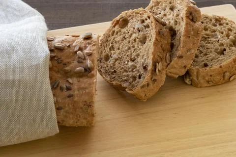 Sliced multi seeded baguette on a bread board Stock Photos