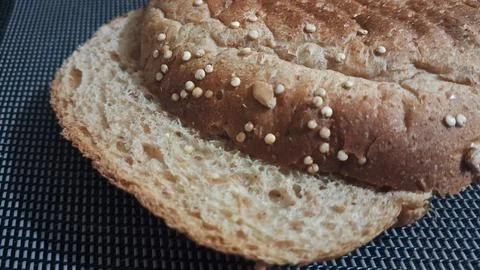 Sliced multigrain bread bun topped with healthy white quinoa seeds Stock Photos