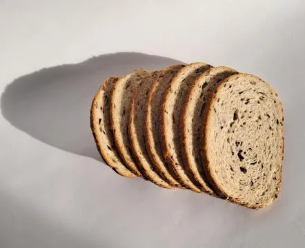 Sliced multigrain bread loaf arranged on white background. Stock Photos