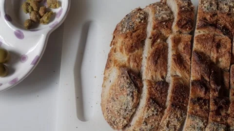 Sliced olive bread with olives and pistachios on a white plate Stock Footage 312775584