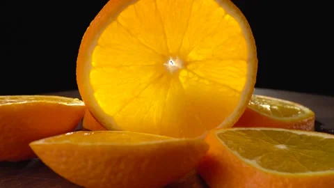 Sliced orange closeup on a black background Stock Footage 134486185