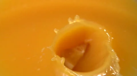 Sliced orange falling into orange juice. slow motion. Video stock 56687559
