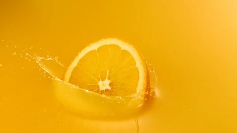 Sliced orange falling into orange juice, Slow Motion Video stock 85651747