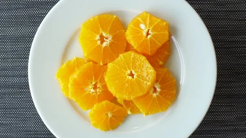 Sliced orange on a plate rotates. View from above. Healthy food concept with  Stock Footage 110640025