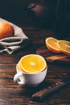 Sliced orange in a white cup Stock Photos