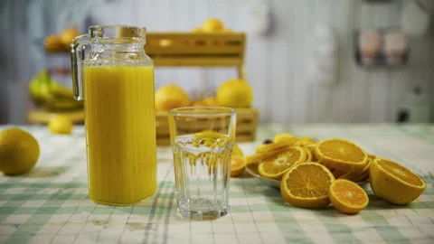 Sliced oranges and pitcher on kitchen counter - cinematic medium tracking shot Stock Footage 341243023