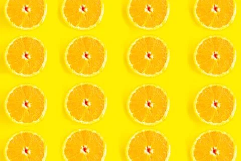 Sliced oranges pattern on yellow background, minimal concept Stock Photos