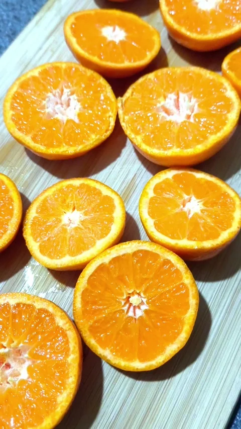 Sliced oranges rotating on a cutting board Video stock 337491403