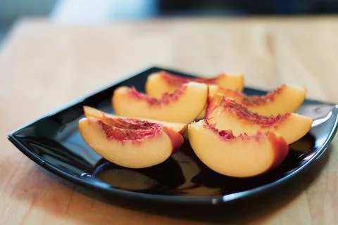 Sliced peach on a plate. Stock Photos
