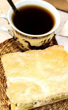 A sliced piece of cake on the table next to a cup of coffee. Fotos Stock