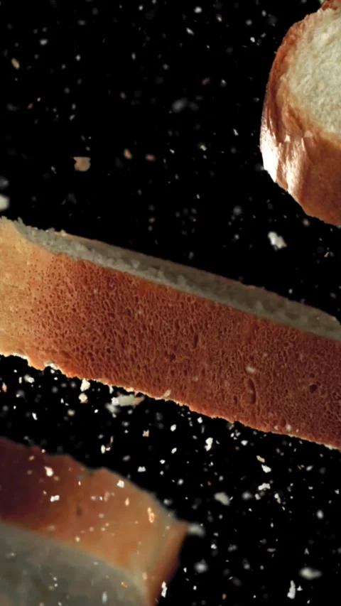 Sliced pieces of bread fly up and fall down. Filmed on a high-speed camera at Stock Footage 335370086