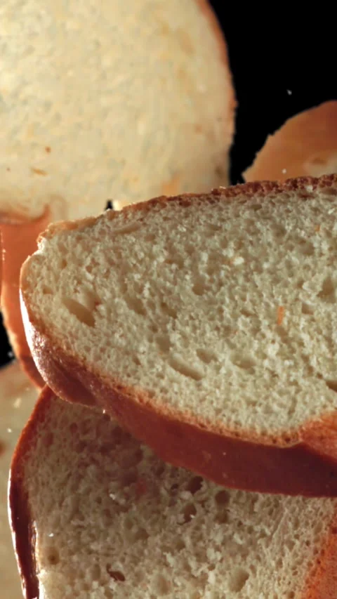 Sliced pieces of bread fly up and fall down. Filmed on a high-speed camera at Stock Footage 335379255