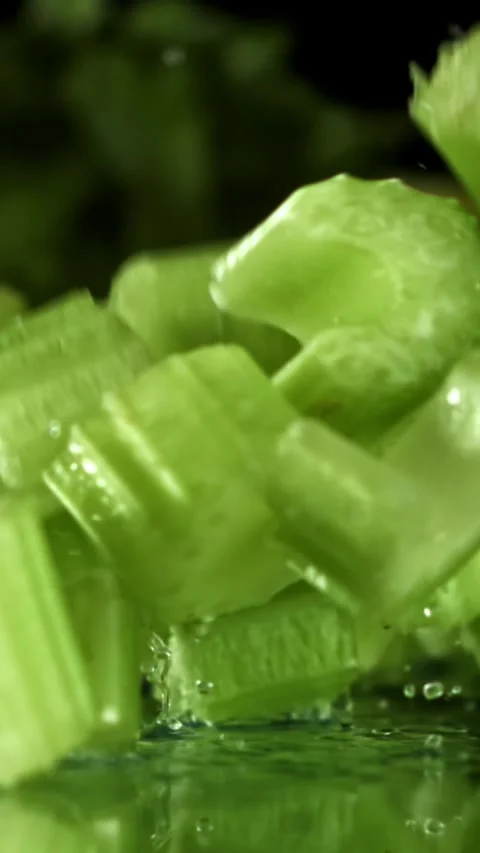 Sliced pieces of fresh celery fall on the table. Filmed on a high-speed camera Stock Footage 335372186