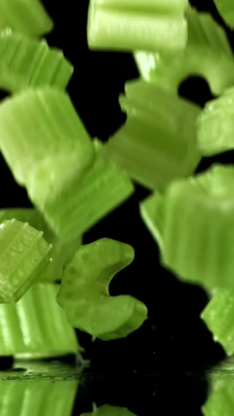 Sliced pieces of fresh celery fall on the table. Filmed on a high-speed camera Stock Footage 335372978
