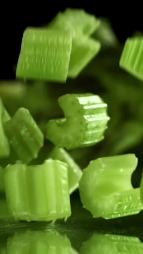 Sliced pieces of fresh celery fall on the table. Filmed on a high-speed camera Stock Footage 335373518