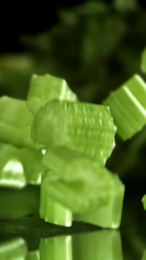 Sliced pieces of fresh celery fall on the table. Filmed on a high-speed camera Stock Footage 335374620