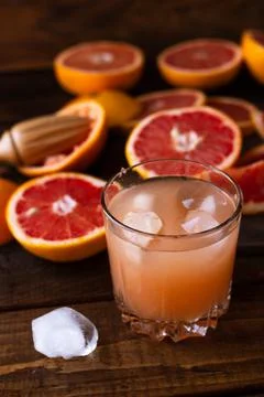 Sliced pieces of grapefruit lie on the table on the dark wooden countertop. n Stock Photos