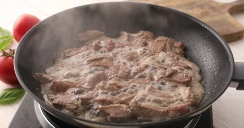 Sliced pieces of meat are fried in a frying pan. Stock Footage 250019952