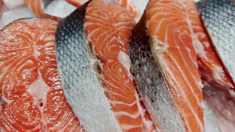 Sliced ??pieces of red fish lying on the window of a fish shop. Close-up. Stock Footage 231990986
