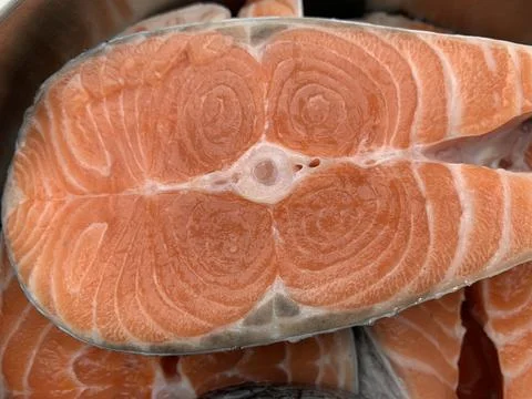 Sliced pieces of red fish. In a metal bowl, salmon steak. Salmon is prepared  Stock Photos