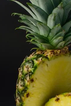 Sliced pineapple fruit close up, black background Foto stock