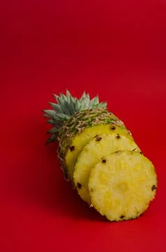 Sliced pineapple fruit on red background Stock Photos