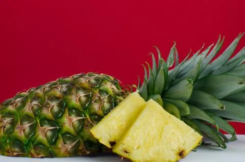 Sliced pineapple fruit on red background Foto stock